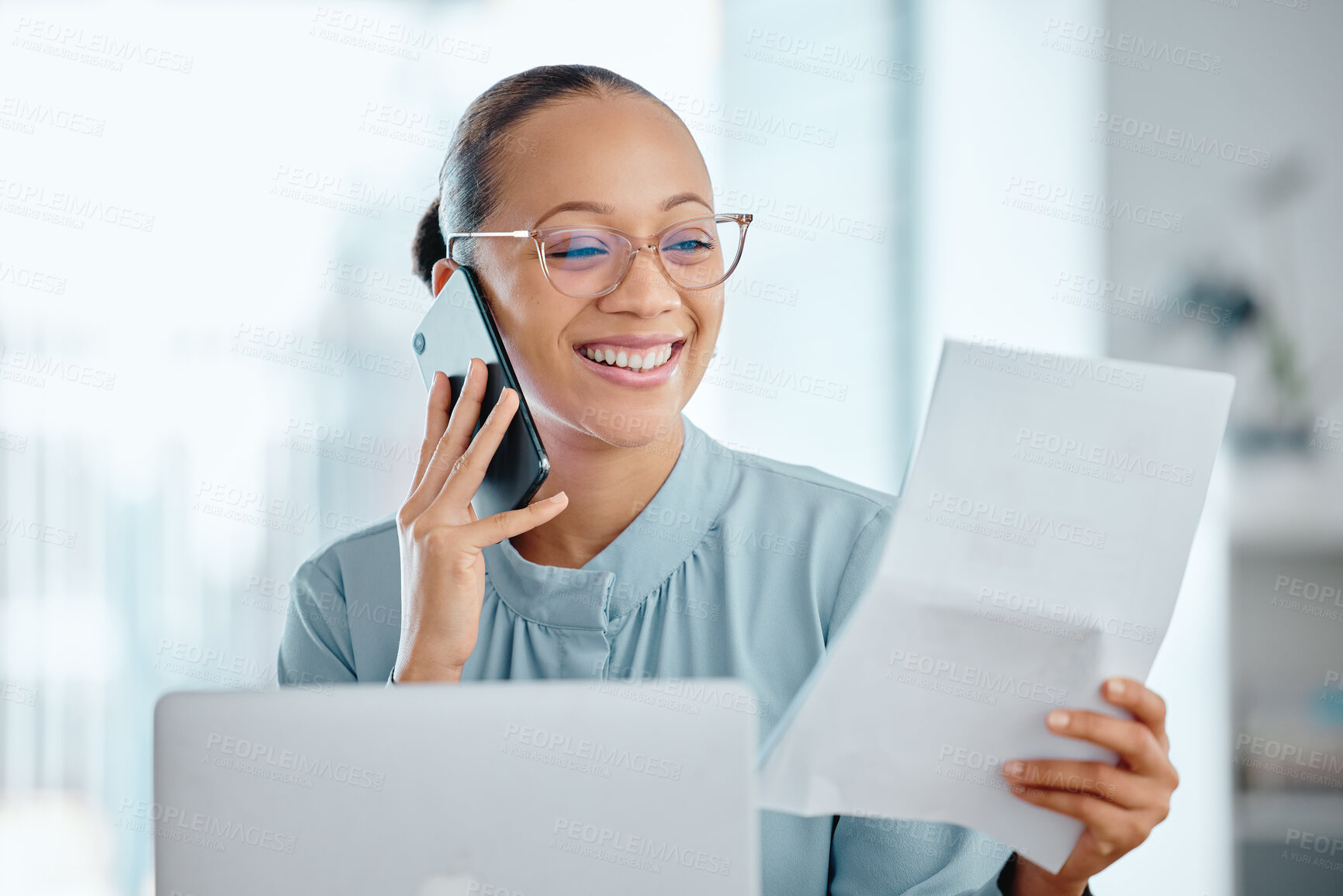Buy stock photo Happy business woman talking on a phone call, discussing contract with a client or colleague. Female executive holding and reading documents or paperwork, sitting in front of a laptop at office desk.