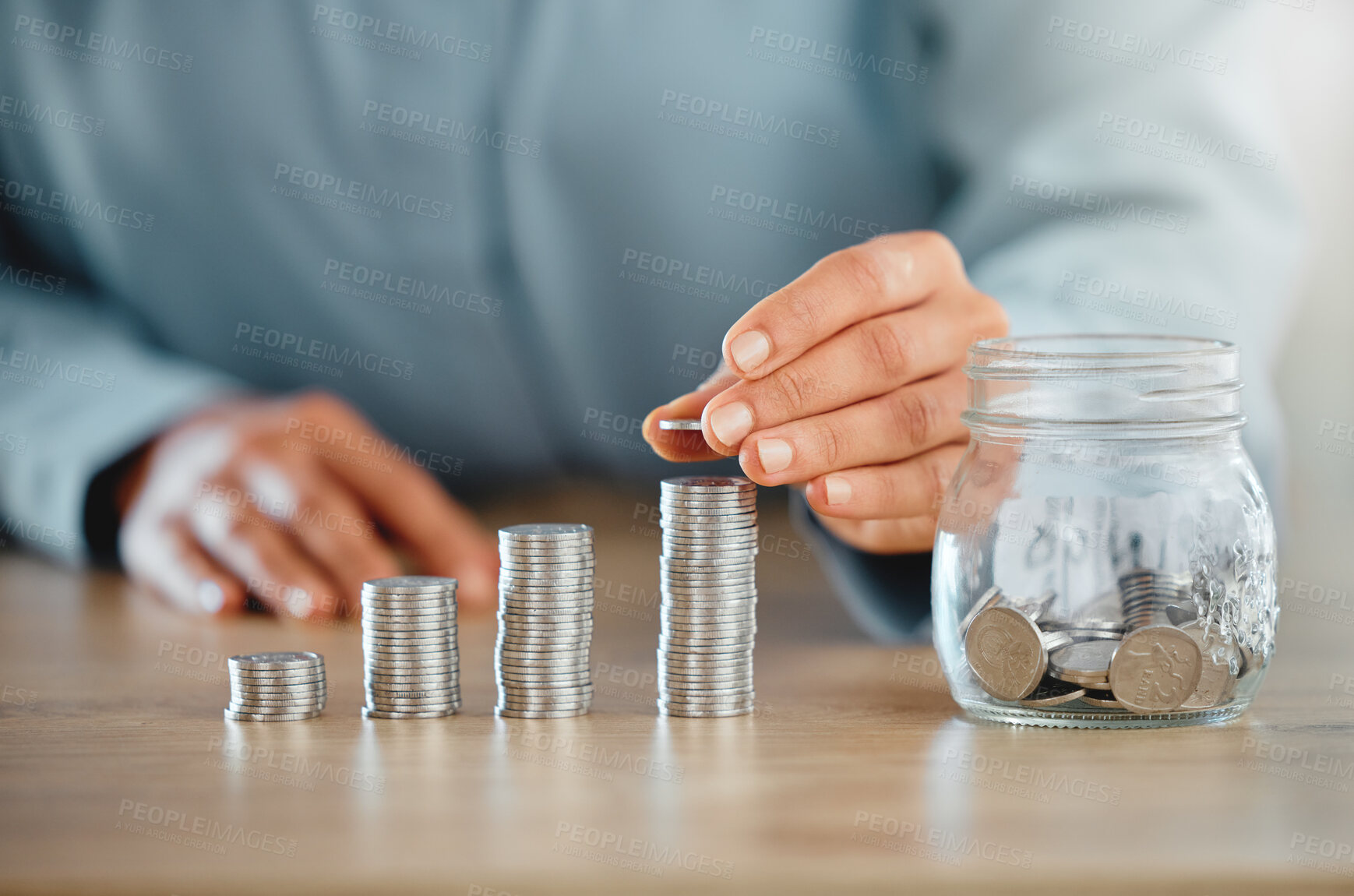 Buy stock photo Savings, money and banking done by a business person on a table in an office at work alone. Closeup of the hands of a corporate professional stacking, piling and sorting coins to calculate budget