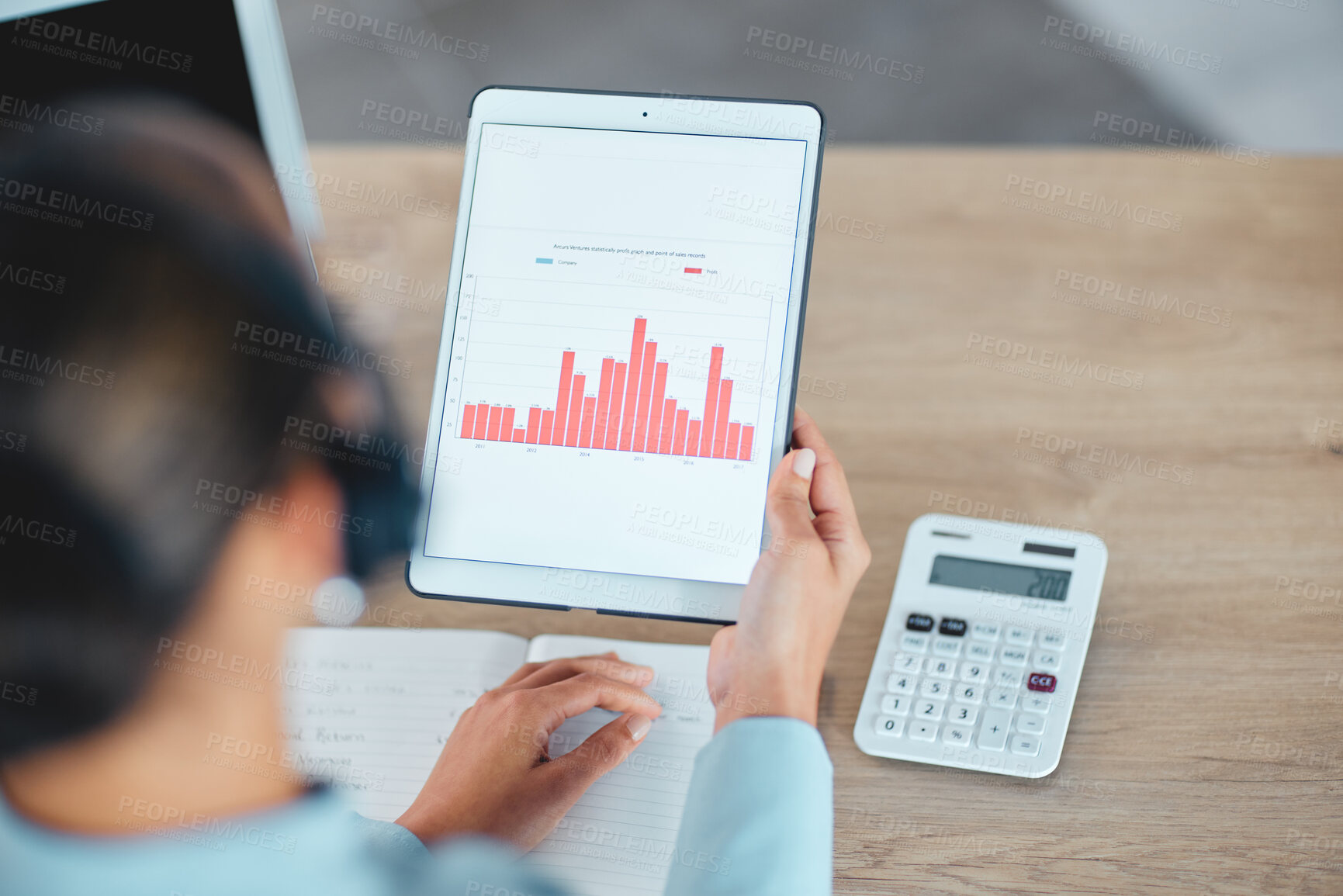 Buy stock photo Financial advisor reading and studying finance data charts, graphs and reports on tablet in office. Above view of professional holding, analyzing and calculating profit and loss information
