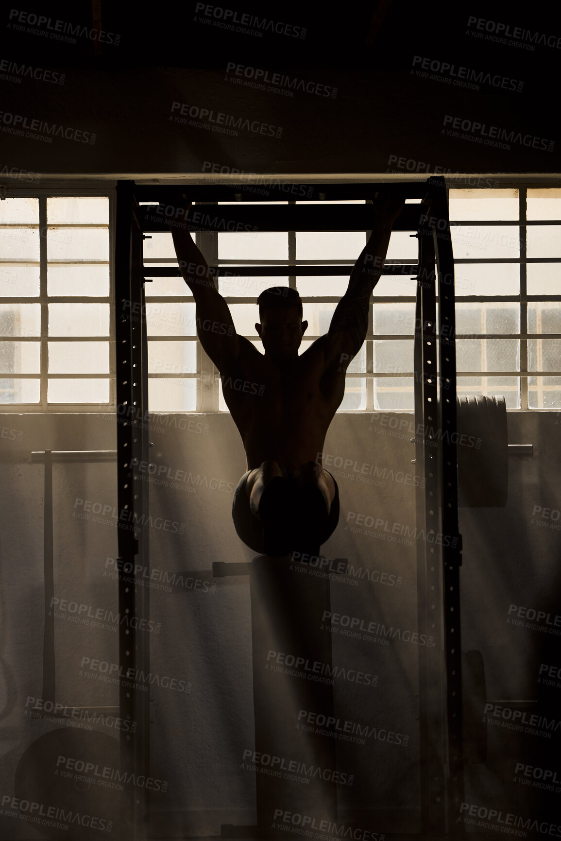 Buy stock photo Fit, active and healthy man in dark gym for training, workout and exercise. Silhouette shadow of sporty, athletic or strong athlete bodybuilding or weightlifting for strong, powerful or toned muscles