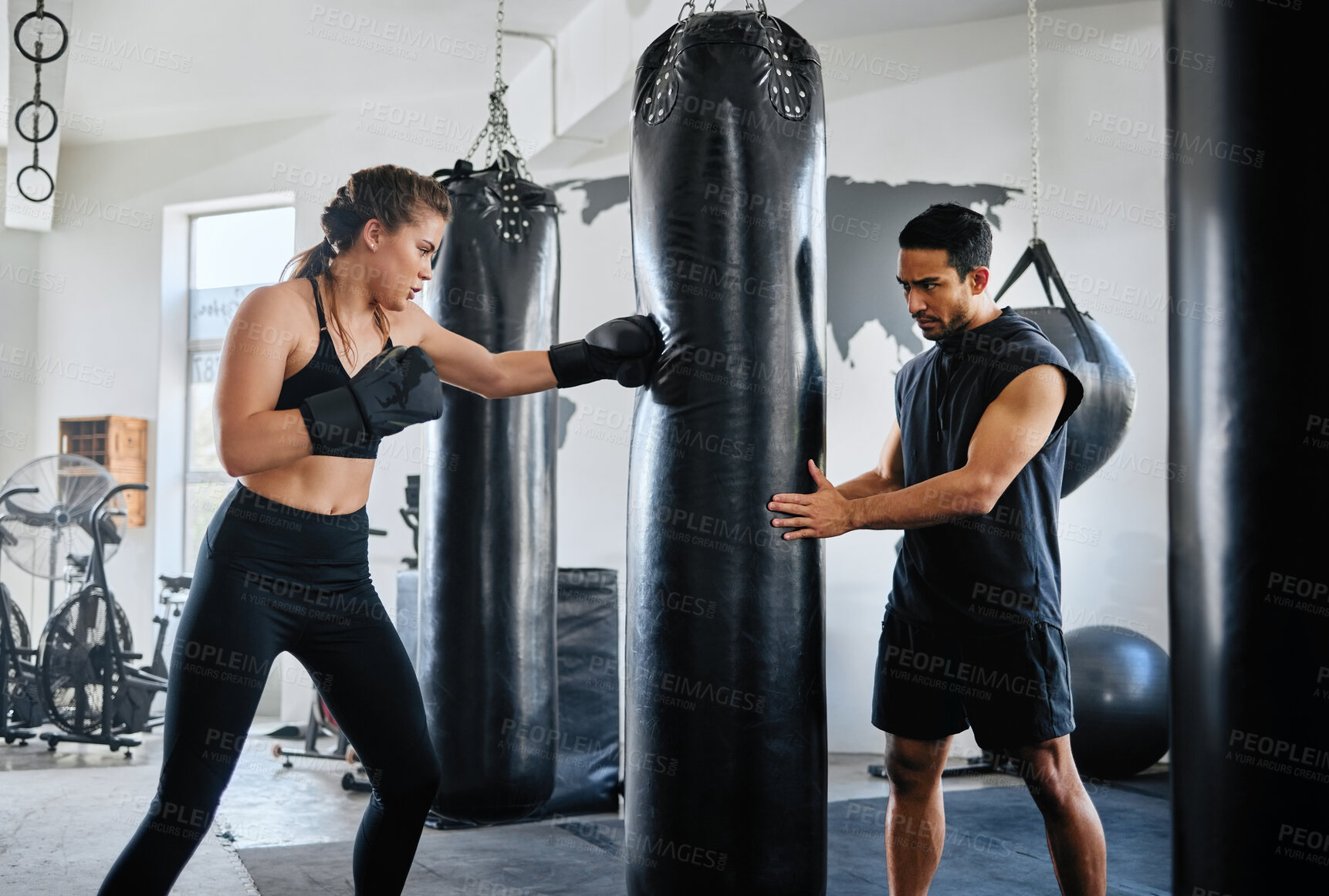 Buy stock photo Healthy, fit and active female boxer training, exercising and sparring with her coach, trainer or instructor in the gym or health club. Young woman preparing for a boxing fight, match or competition