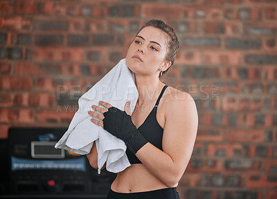 Buy stock photo Healthy, fit and active female boxer wiping sweat with a towel after a workout in the gym or health club. Young woman completing and finishing training, exercising and working out in a fitness studio