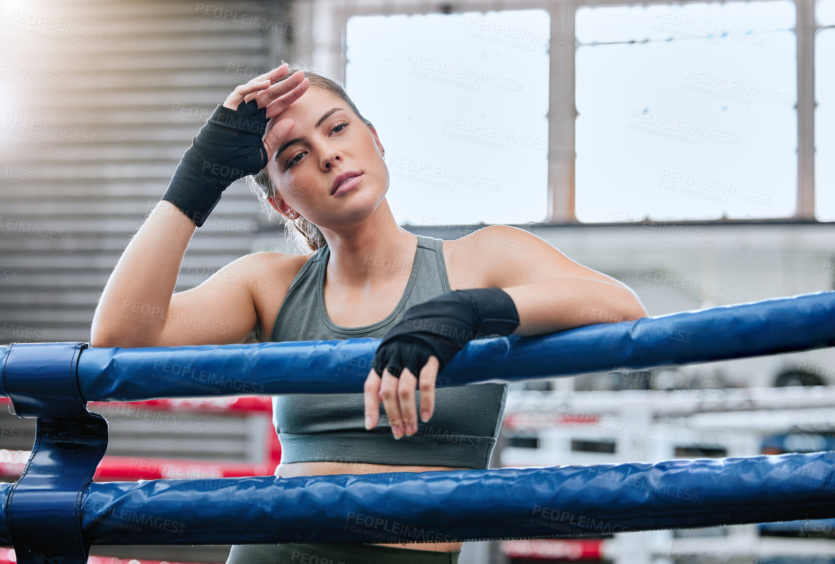 Buy stock photo Confident, active and toned female fitness athlete in a boxing ring after a fight, match or sparring session in a gym. A healthy, fit and strong woman ready to exercise, workout and do training