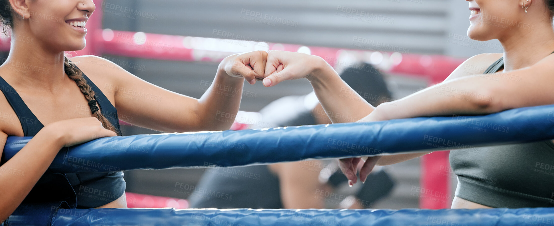 Buy stock photo Closeup of happy women showing support, motivation and unity with fist bump at the gym or fitness club together. Two female boxers expressing success, teamwork and standing united at a sports center