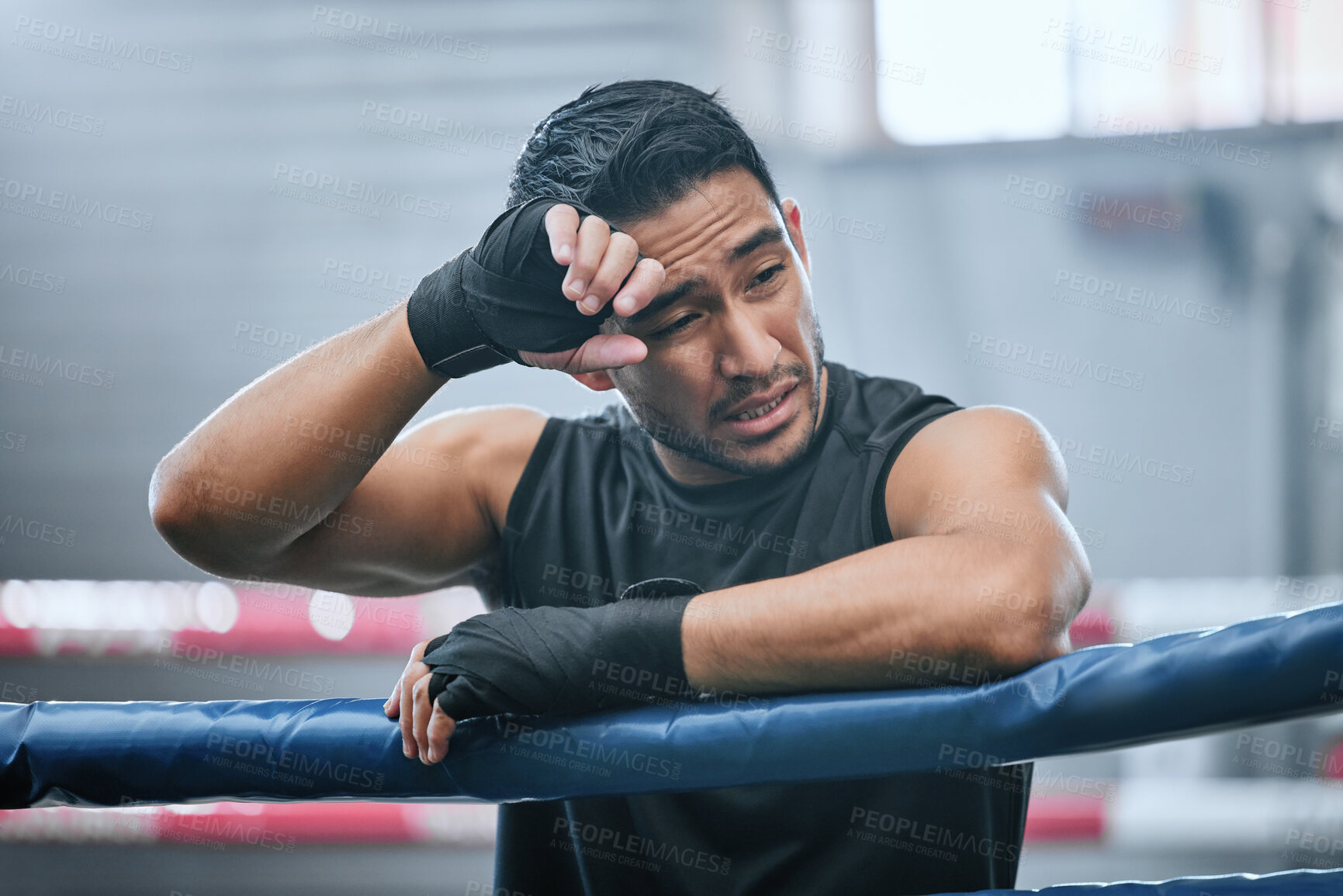 Buy stock photo Fit, active or healthy boxing man feeling tired, hot and wiping sweat after workout, training or exercise in ring. Sporty, athletic or strong boxer upset after losing kickboxing fight or sports match