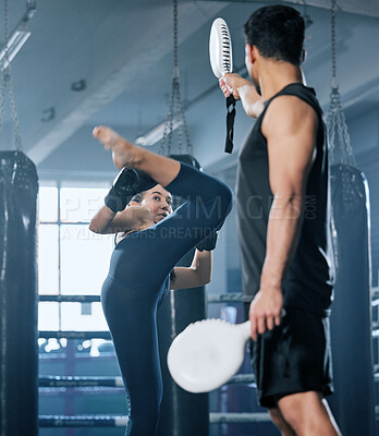 Buy stock photo Kickboxing, combat and fighter woman training high kicks with her coach in the gym. Female athlete performing martial arts and training, exercising or doing a workout for a fight with her trainer
