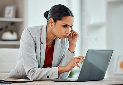 Serious, concentrating and African business woman reading an email, browsing online or looking for ideas on a laptop alone in an office at work. One black female corporate professional working