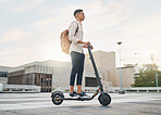 Riding an electric scooter into a carbon, emission free future. A casual business man driving an escooter in a city street on the morning commute. Eco friendly travel and transport is the way forward