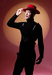 Fashion, style and man with vitiligo in a studio with a grungy, edgy and goth outfit with an orange light. Stylish, aesthetic and cool male model with a skin depigmentation posing by a red background