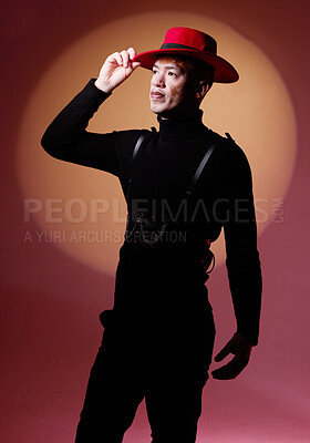Buy stock photo Fashion, style and man with vitiligo in a studio with a grungy, edgy and goth outfit with an orange light. Stylish, aesthetic and cool male model with a skin depigmentation posing by a red background