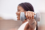 Fitness, sports or black woman with dumbbell for strong arms, bicep muscles or strong shoulder in training. Outdoors, blurry or African girl hands weightlifting in an exercise or workout in Nigeria