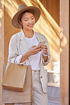 Woman, shopping bag and phone for communication, ecommerce and online chat about sale, discount and savings while outdoor. Happy customer or asian female with smartphone for banking and retail coupon