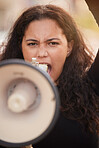 Woman, megaphone and protest in the city for human rights, gender based violence or equality in the outdoors. Female activist shouting, screaming and speaker for discrimination, community or change