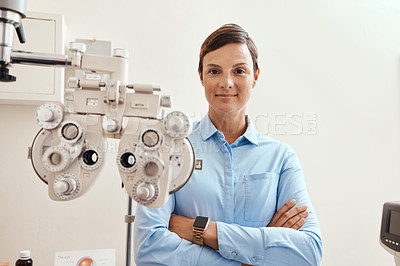 Buy stock photo Confident, happy and proud optometrist standing with arms crossed, ready for checkup and preparing equipment in an optometry office. Smiling, successful and wellness portrait of an ophthalmologist 