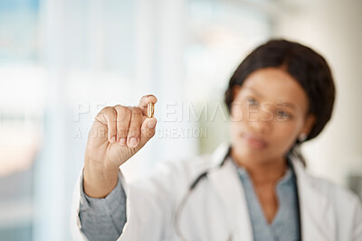 Buy stock photo Medical doctor with medicine pills in hand while working in a hospital or clinic. Woman healthcare professional or expert showing oil capsule, vitamin or omega 3 supplement in hospital or pharmacy