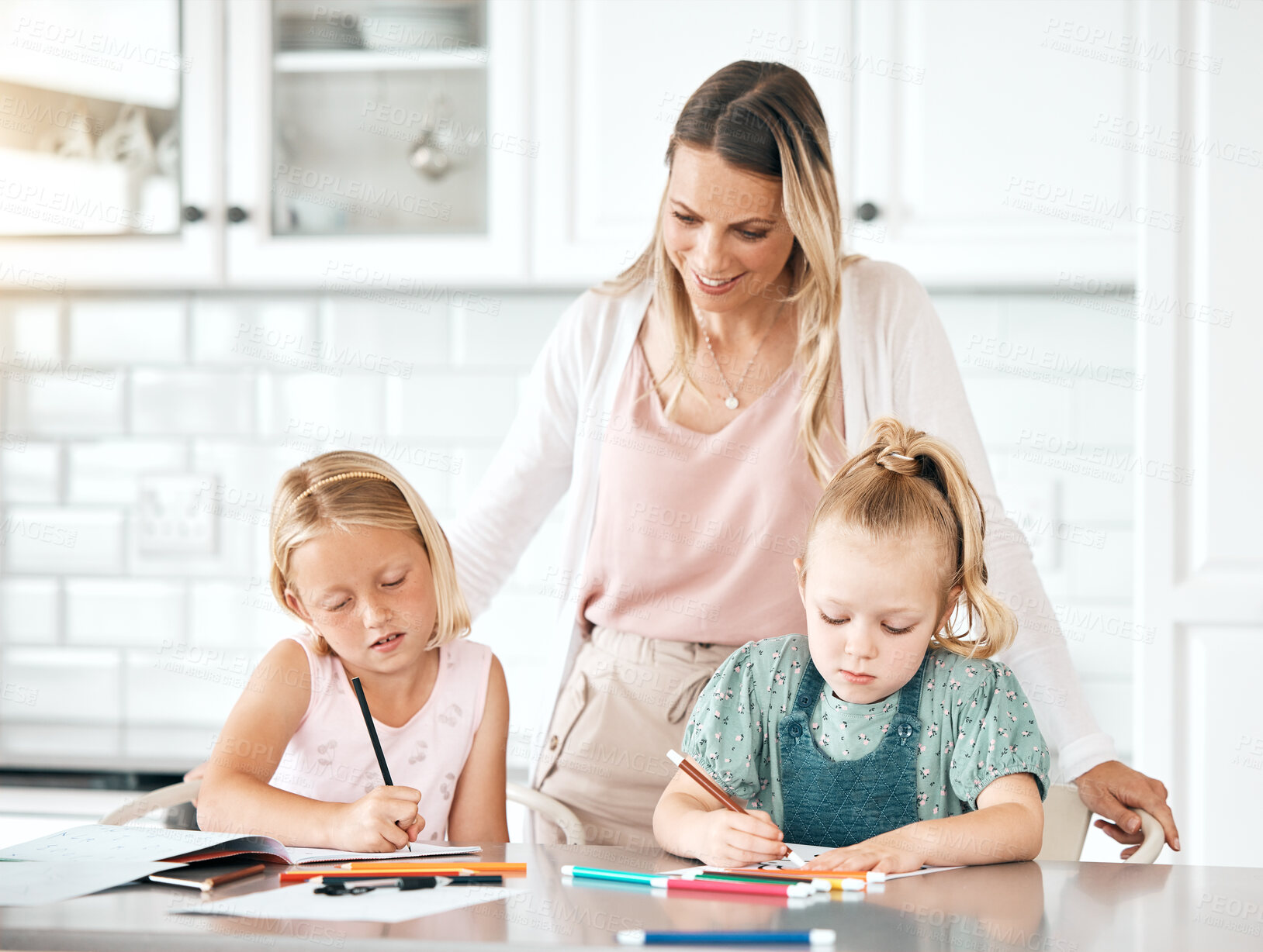Buy stock photo Education, learning and homework with a girl, her sister and their mom in the kitchen at home. Single mother helping, assisting and teaching her daughter with school, studying and coloring or drawing