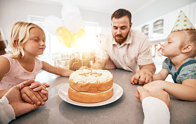 Buy stock photo Family praying at birthday party, making a wish with cake and celebrating a special occasion together at home. Parents teaching children faith, saying a prayer and sitting at table during celebration