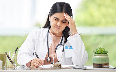 Buy stock photo Headache, stress and burnout medical doctor working in hospital, looking in pain and writing in a book while sitting in office at clinic. Tired, unhappy and professional female healthcare worker