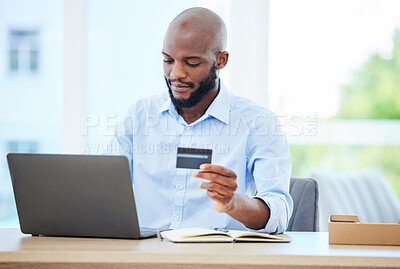 Buy stock photo Shopping with credit card and laptop, making online payment and buying product on an app while sitting in an office at work. Professional, corporate and African business man buying items and banking