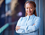 Confident, proud and satisfied business woman standing with arms crossed at office, ceo showing smile and leader working corporate on balcony at work. Portrait of black female boss expressing success