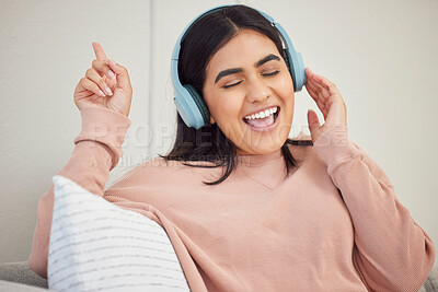 Buy stock photo Singing woman wearing headphones to listen to music, enjoying favorite songs and having fun alone at home. Happy, cheerful and joyful female relaxing with good music and listening to a podcast