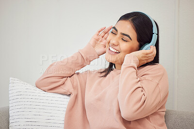 Buy stock photo Headphones, listening to music and dancing to fun, happy radio songs while relaxing on home living room sofa. Smiling, cheerful and singing woman having fun and enjoying podcast or dance media sound