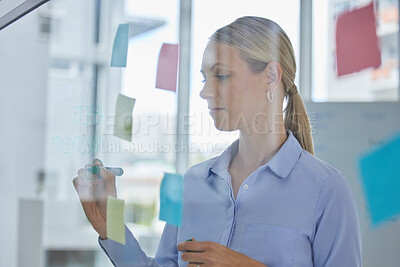 Buy stock photo Creative, schedule and planning of a female designer writing plans for tasks or ideas at the office. Woman in design working on a project plan or strategy to organize work and productivity.