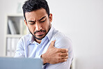 Bad muscle pain in the arm, shoulder and body after an injury and ache while working in the office. Angry, upset and frustrated businessman with a painful strain, hurtful and sore sitting at his desk