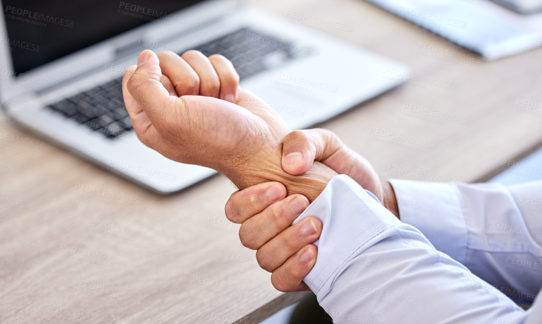 Buy stock photo Business man with bad wrist pain in the hand after an injury and ache while in the office. Closeup of a corporate male with a painful strain, hurtful and sore sitting at his desk