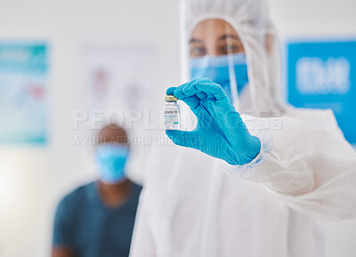 Buy stock photo Covid vaccine, cure or treatment for covid19 held by a healthcare professional in a hospital. Portrait of a doctor wearing a protective hazmat suit holding a bottle of medicine in a clinic, hospital