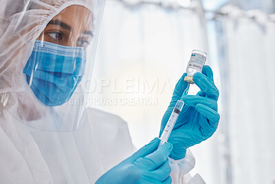 Buy stock photo Medical scientist, doctor or healthcare worker in a safety suit ready to give the covid vaccine. Hospital employee holding, looking and working with care on a corona medicine vial at a hospital