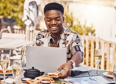 Buy stock photo Man working on a laptop while eating lunch at an outdoor restaurant with 5g service in the city. Casual employee doing research on internet with a computer while having sandwich and champagne at cafe