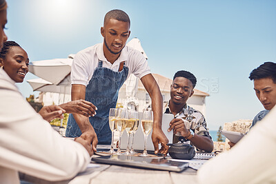 Buy stock photo Beach restaurant, waiter and champagne celebration with friends. Hospitality, fine dining and a relaxing outdoor meal with people. Summer holiday or lunch break outside with view of the ocean.