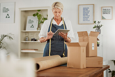 Buy stock photo Packing parcel or package in shop, online fashion order on tablet, clothes boutique or design workshop. Mature tailor or seamstress packaging, boxing or wrapping clothing product for courier delivery