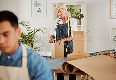 Buy stock photo Fashion, design and style with a tailor, seamstress or creative designer packing boxes for shipment and delivery. Female stylist preparing a box to complete an order in her studio or workshop