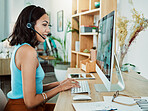 Working, typing and talking customer service support agent online helping a client on a computer. Female web help digital call centre employee with headset giving internet advice or tech assistance