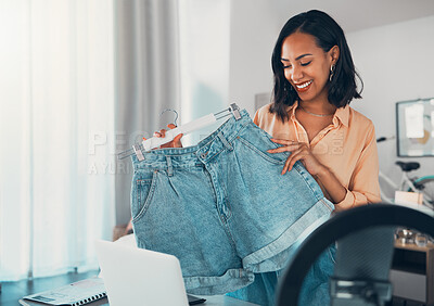 Buy stock photo Fashion influencer, style and design with a creative and trendy female holding denim shorts in her small business and startup vlog. Fashionable, stylish and modern clothing for a social media blog