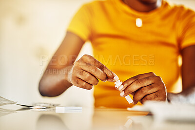 Buy stock photo Hands of African female with HIV and Aids at home blood self test kit sitting at a desk waiting to check for results. Closeup of young afro woman with medicine or pills for a medical condition.   