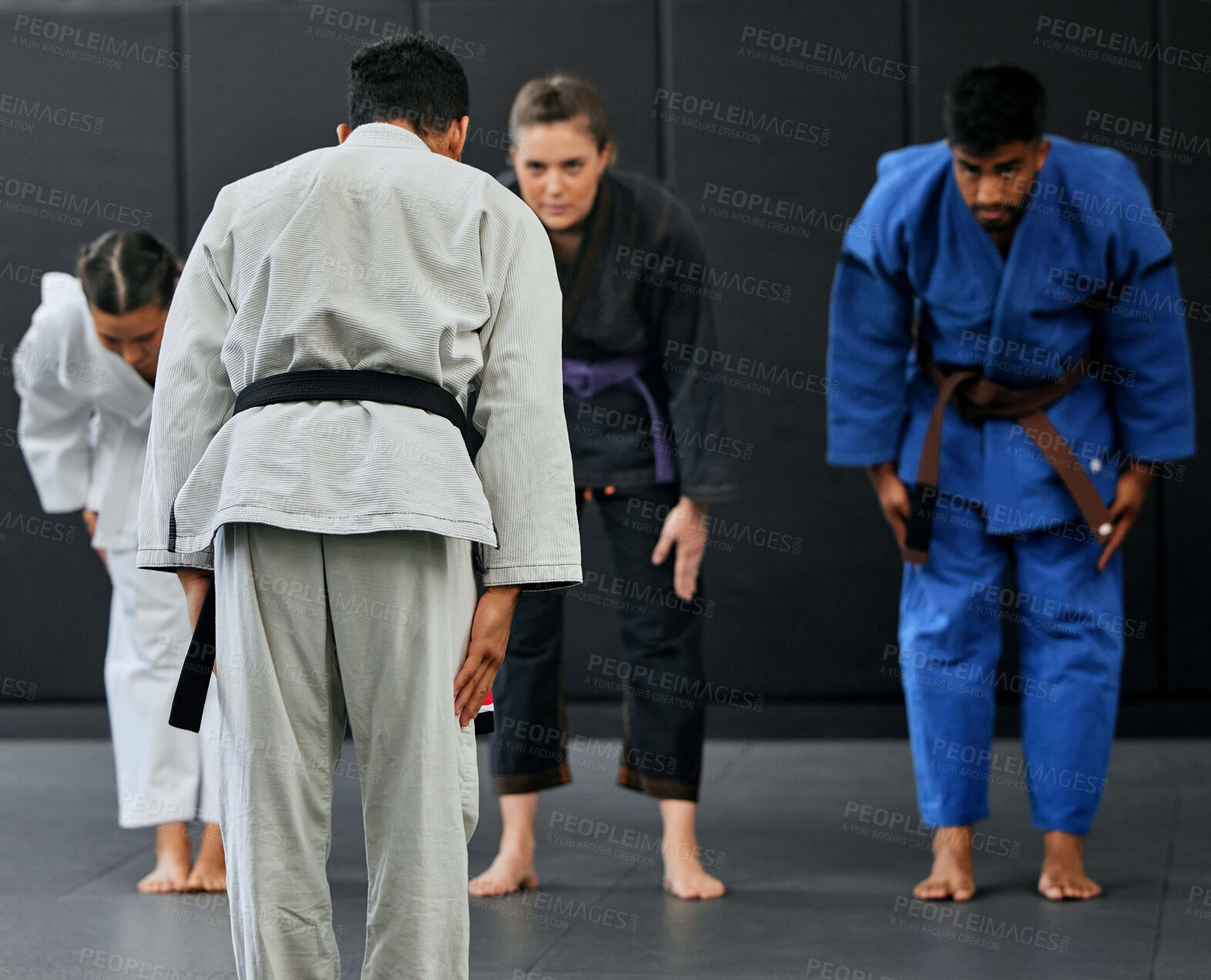 Buy stock photo Fitness, strength and respect between karate trainer leading a class, bow and greeting martial arts student at a dojo or studio. Diverse group training and learning self defense and endurance skills