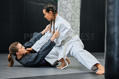 Buy stock photo Mma, karate and jiu jitsu with two female athletes practicing, training and sparring in fight class. Healthy, fit and active women in gi or uniform learning self defense for safety and health