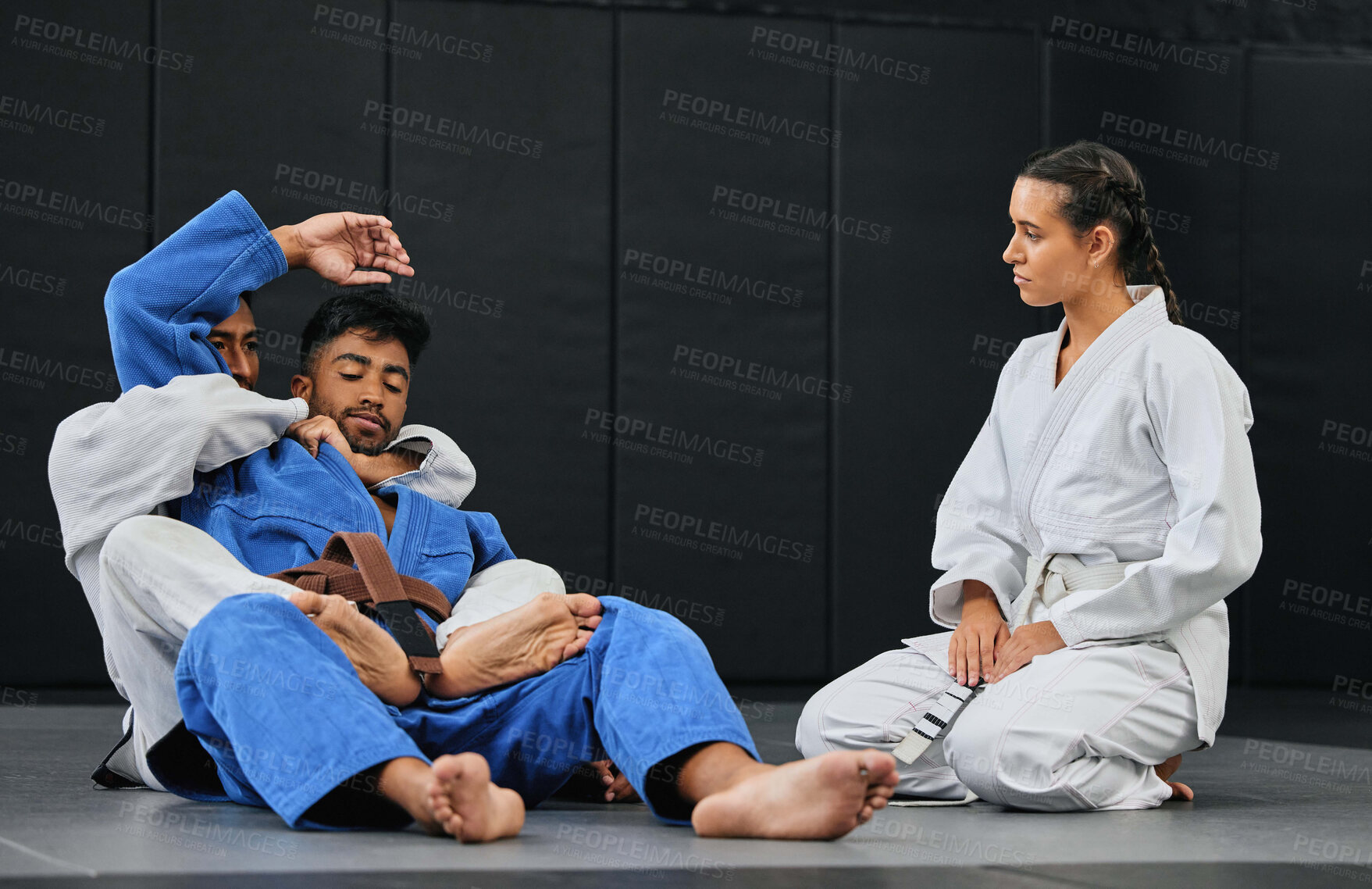 Buy stock photo Group of athletes in a martial arts fight workout for fitness at a training studio. Active, fit and diverse team of sporty people practicing sparring in taekwondo or jujutsu at an exercise dojo.