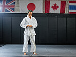 Professional karate student dressing and prepare for practice in a dojo or club. Female mix martial art athlete tying belt in training for a fight, competition or exercise workout in a sport studio