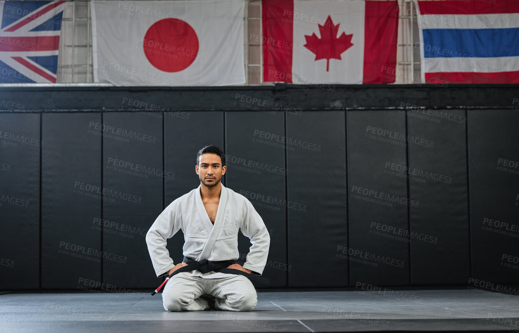 Buy stock photo Martial arts, black belt and sitting fighter inside dojo for training. Defence club, champion or coach exercising in his sportswear. Karate or mma man looking with focus and discipline at the gym.