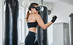 Female boxer using VR goggles to train, exercise and stay fit and healthy in a modern fitness gym. Sporty, exercising and wellness expert or fighter doing an active workout routine or training alone