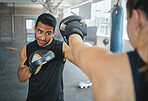 Boxer and coach training workout together at the sports fitness and wellness gym. Professional young martial arts athlete practice and exercise boxing with a personal trainer for a competitive fight