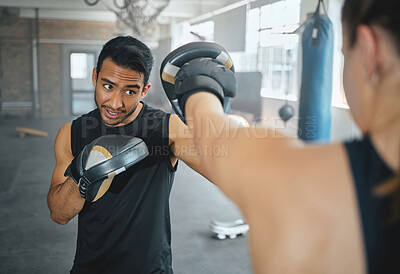 Boxer and coach training workout together at the sports fitness and wellness gym. Professional young martial arts athlete practice and exercise boxing with a personal trainer for a competitive fight