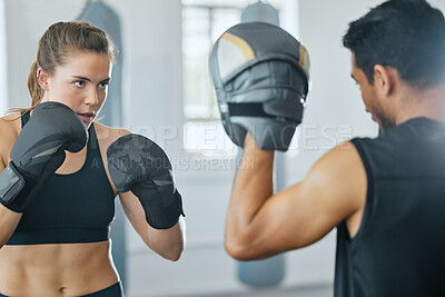 Boxing female boxer at gym with sports personal trainer practicing or training together for fight or match. Fitness and wellness coach teaching fit active athlete or client fighting exercise workout