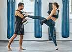 Training kickboxing and learning to fight, a male trainer and woman getting fit in gym. Fitness, motivation and female empowerment. Strong kick and healthy exercise, a young lady and her sports coach