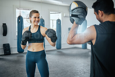 Boxing gym, combat sport and woman training for fight, exercise and workout in fitness club. Happy female, strong athlete and smile sports people fighting with personal trainer, coach and kick boxer