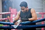 Fit, active and healthy athlete looking tired after workout, unhappy and drinking water after boxing for fitness. Young, sporty and Asian man breathing heavily, resting and taking break from exercise